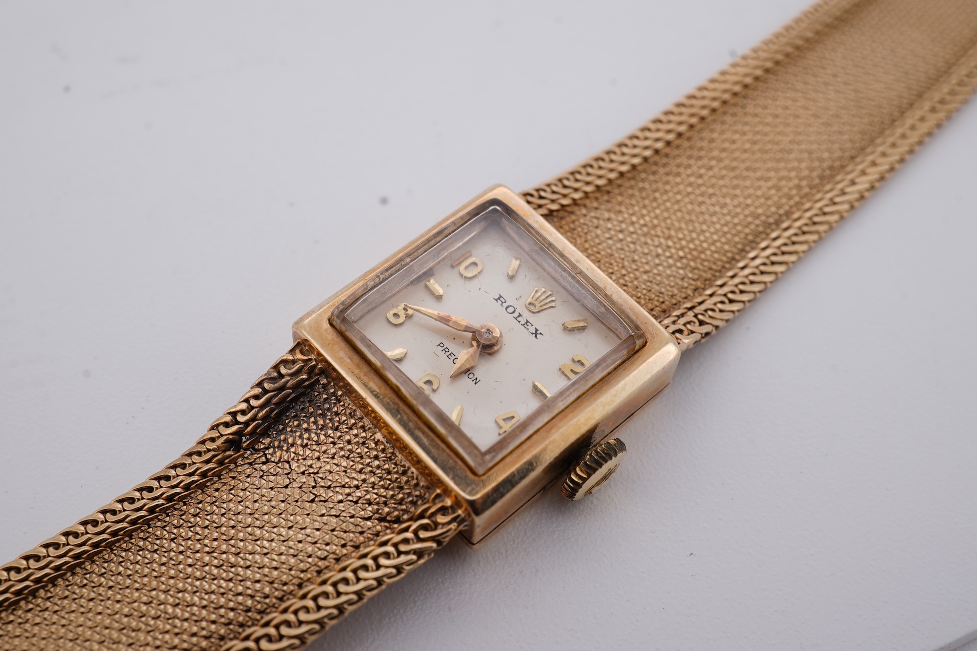 A lady's 1960's 9ct gold Rolex Precision manual wind wrist watch, with square dial, on an integral 9ct gold bracelet, the clasp with Rolex crown, overall length 15cm, gross weight 22 grams (bracelet a.f.)
